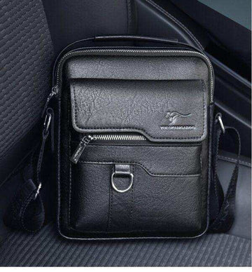 Black leather crossbody shoulder bag with front zipper pocket and adjustable strap on car seat