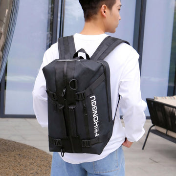 Black FEIHONGGU travel backpack with multiple straps, worn by man in white shirt, ideal for students and laptop carry