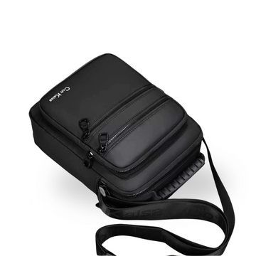 Black compact crossbody bag with multiple zippers and adjustable strap for travel or daily use