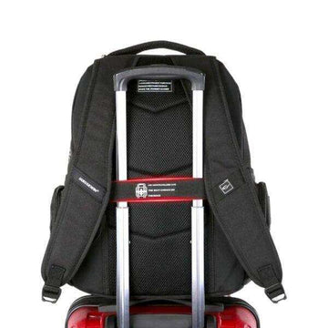 Black travel backpack fitted on top of red rolling suitcase with telescopic handle