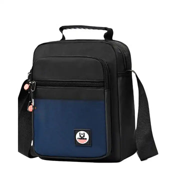Black and navy blue crossbody bag with adjustable strap, front zipper pocket, and fashion patch