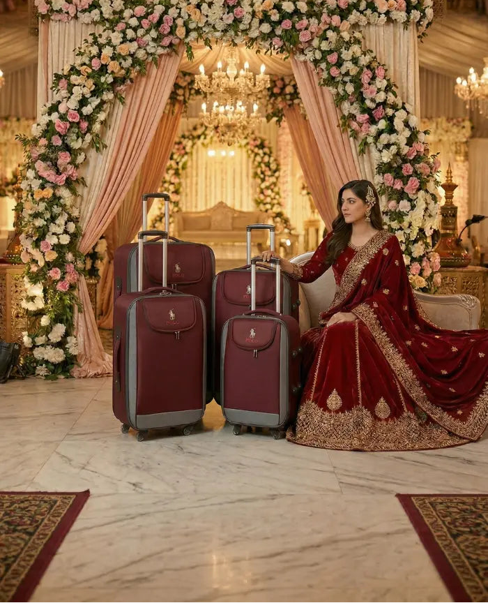 Decorative arch with floral arrangements and a person in traditional attire with suitcases.