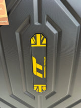 Black hardshell suitcase with yellow International Traveller logo, textured surface design