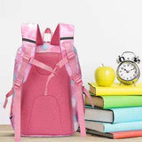 Pink student backpack with polka dots, ideal for school, shown with books, apple, and alarm clock