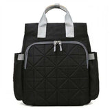 Black quilted backpack with silver handles and zippers, ideal for travel or daily use
