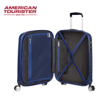 American Tourister blue hardshell suitcase with open interior, cross straps, and 360° wheels for travel