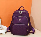 Purple quilted travel backpack with gold zippers, ideal for students and laptop carry