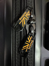 Britbag zipper pull on black luggage with orange logo detail