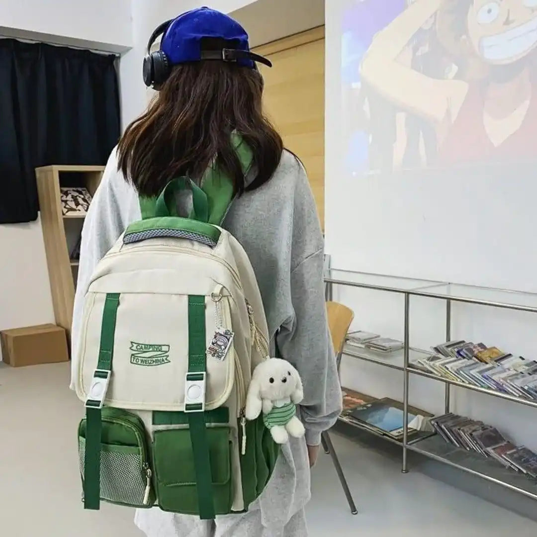 Green and beige student backpack with plush charm, ideal for school or travel