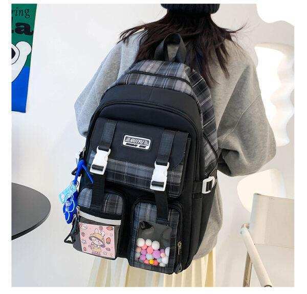 Plaid school backpack with multiple pockets and cute keychain, worn by person in grey hoodie