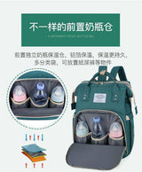Green diaper backpack with insulated front bottle compartment holding three baby bottles