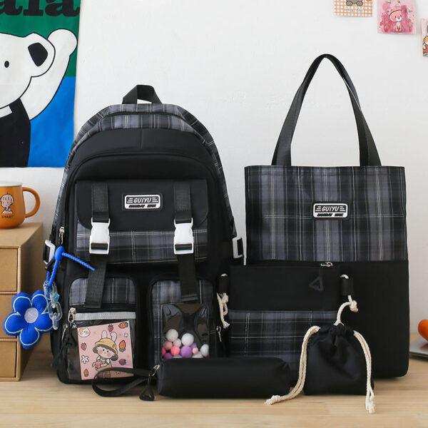 Plaid black school backpack set with matching tote, pouch, and small drawstring bag on desk
