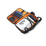 Open laptop backpack with orange interior, multiple compartments, and organized travel essentials