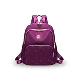 Purple quilted backpack with heart pattern, gold zippers, ideal for travel or school use
