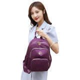 Purple travel backpack for students & laptops, lightweight with front pocket and gold zippers