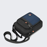Compact black and blue crossbody bag with adjustable strap and front pocket, ideal for travel or daily use.
