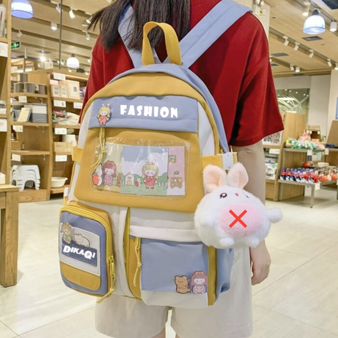 Cute yellow and blue student backpack with cartoon patches and plush bunny charm, perfect for school or travel.