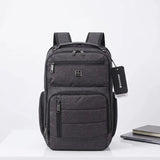 Grey Suissewin laptop backpack with multiple zippers, ideal for students and travel, shown with notebook and laptop.